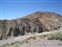 Layered rock formations by parking lot.